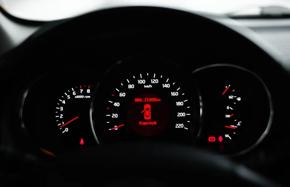 Un voyant moteur orange allumé sur le tableau de bord d'une voiture, gros plan.