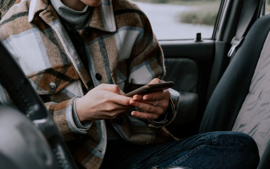 Conducteur qui consulte son téléphone au volant, voiture à l’arrêt